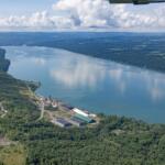 Aerial view of a wide river winding through forested countryside with an industrial complex along the near bank.](#)