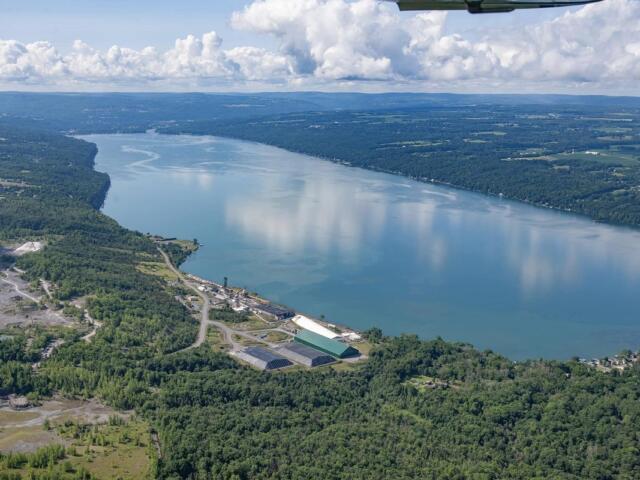 Aerial view of a wide river winding through forested countryside with an industrial complex along the near bank.](#)