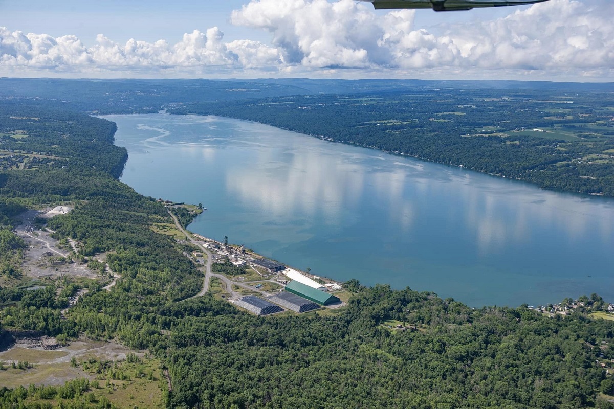 Aerial view of a wide river winding through forested countryside with an industrial complex along the near bank.](#)