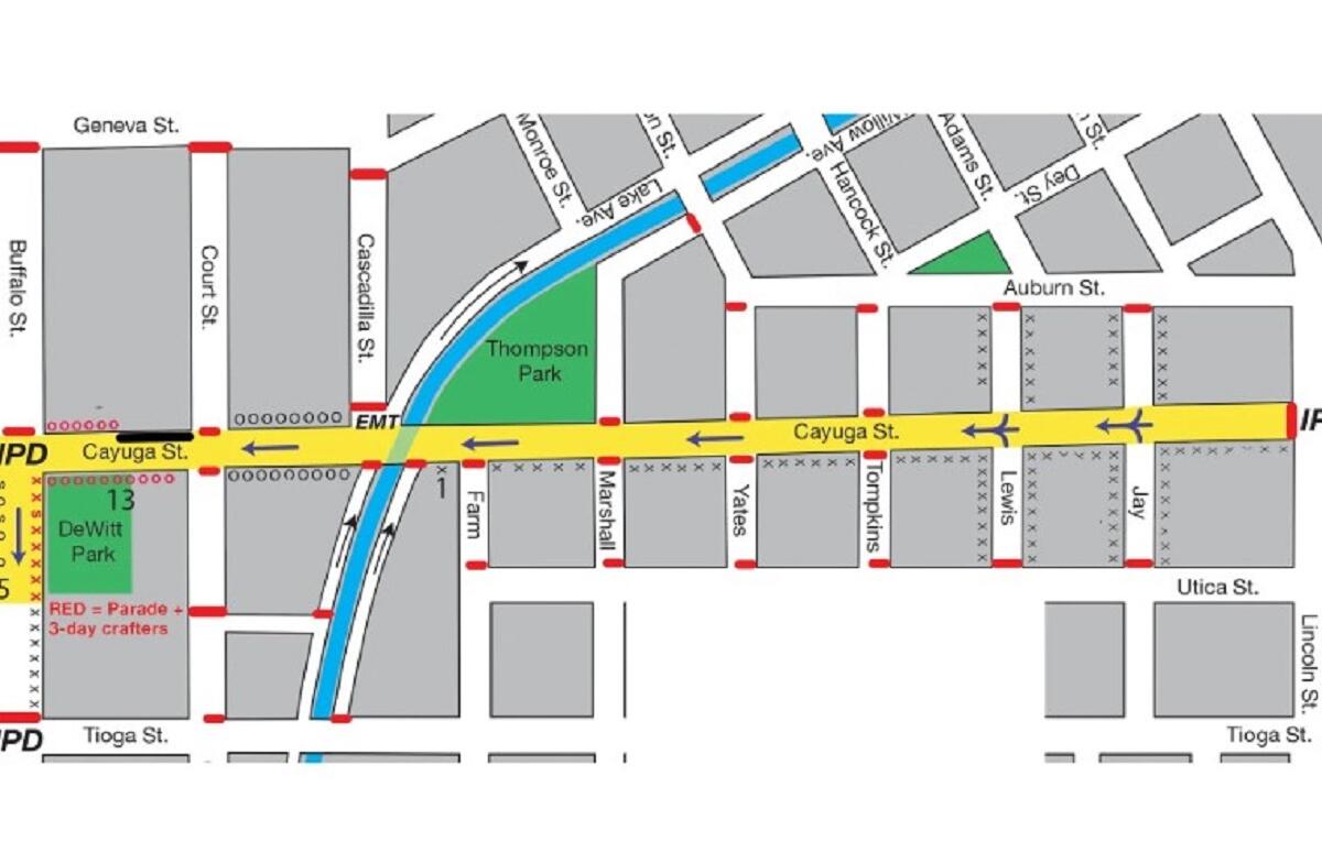 Map showing a parade route through a downtown area: yellow street (Cayuga St) as main path, red dashed lines indicate barriers, green parks (T13 DeWitt Park, Thompson Park), blue canal/stream, and surrounding streets labeled (Geneva St, Buffalo St, Tioga St, Utica St).