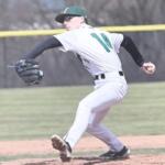 Baseball pitcher in a white uniform and green cap delivering a pitch from the mound, with glove arm extended forward.