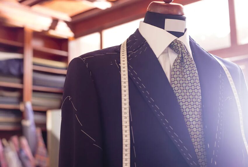 Navy suit on a mannequin with a measuring tape, in a tailor shop.