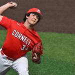Female baseball pitcher in a Cornell red uniform (number 34) throws a pitch on the mound, glove on left hand and ball raised overhead.
