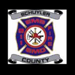 Schuyler County EMS/Fire badge with blue cross, center tools (axe, trumpet) and gray banners reading 'Schuyler' and 'County'
