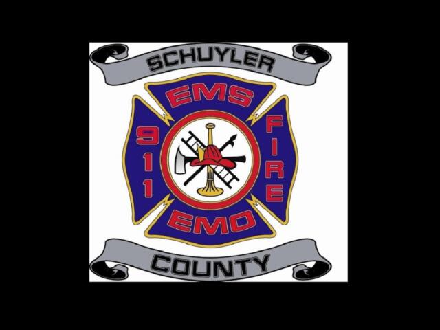 Schuyler County EMS/Fire badge with blue cross, center tools (axe, trumpet) and gray banners reading 'Schuyler' and 'County'
