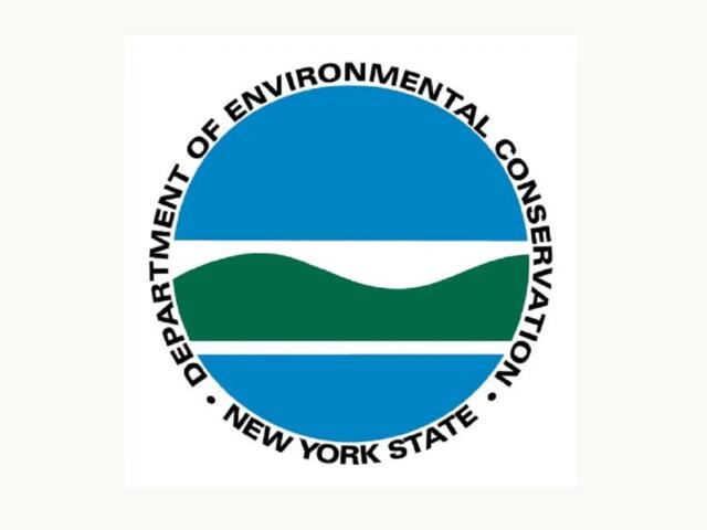Circular logo for the New York State Department of Environmental Conservation (DEC). It shows blue sky and water with green hills, surrounded by the department name in a ring.