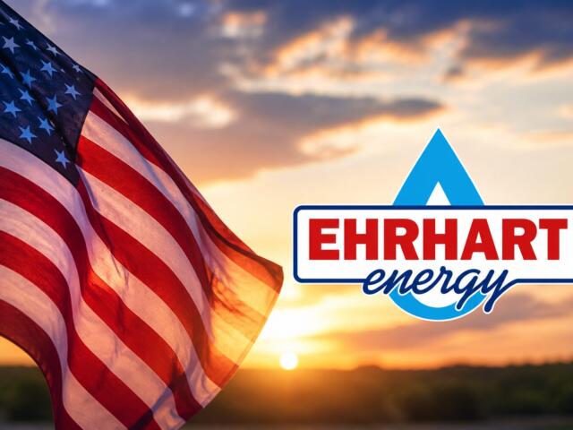 American flag waving at sunset beside the EHRHART Energy logo