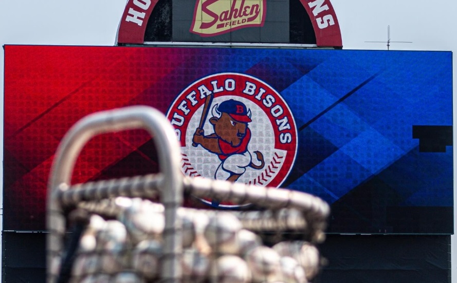 Scoreboard displaying the Buffalo Bisons logo in a red‑to‑blue gradient background; blurred stadium equipment in the foreground.