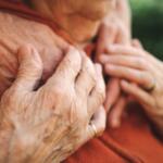 Elderly person's hands over younger person's hands