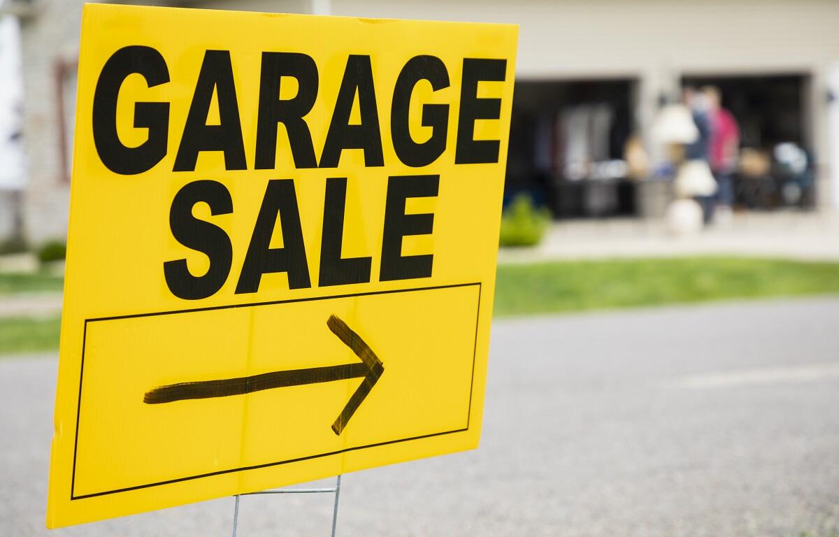 Bright yellow garage sale sign with bold black text and a right-pointing arrow