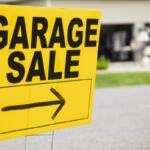 Bright yellow garage sale sign with bold black text and a right-pointing arrow