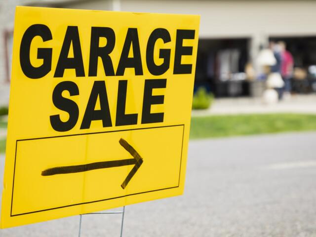 Bright yellow garage sale sign with bold black text and a right-pointing arrow